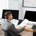 A business director in an office with a landline phone system